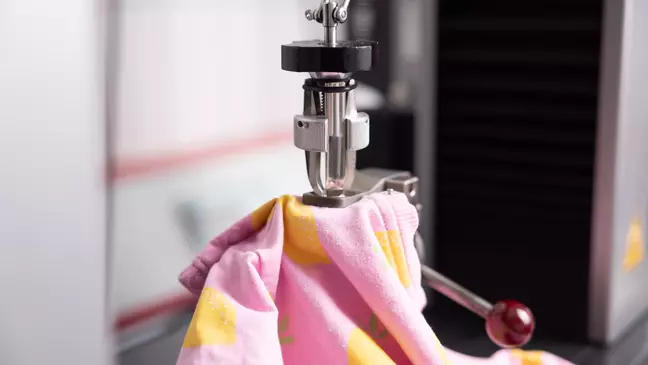 Un capo di abbigliamento dell’assortimento KiK viene sottoposto a controlli in laboratorio, a rappresentare l’impegno dell’azienda nella gestione della qualità dei prodotti