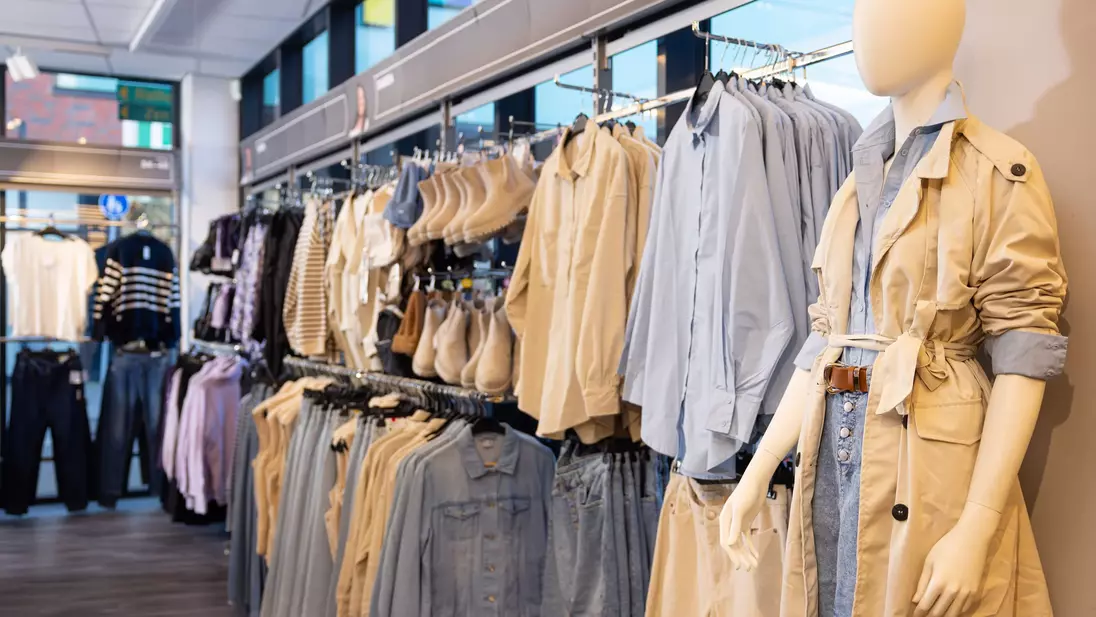 Presentazione di outfit completi sulla parete espositiva di un punto vendita KiK