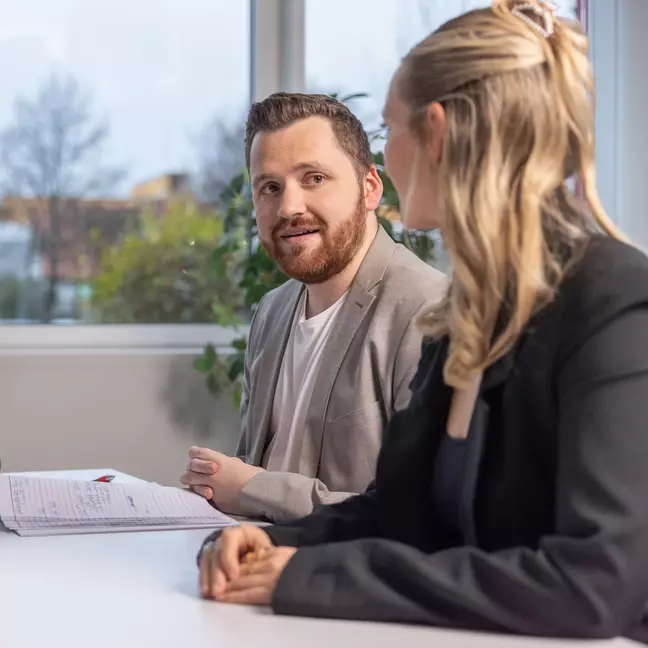 Due persone sono sedute durante un colloquio di lavoro in un moderno ufficio
